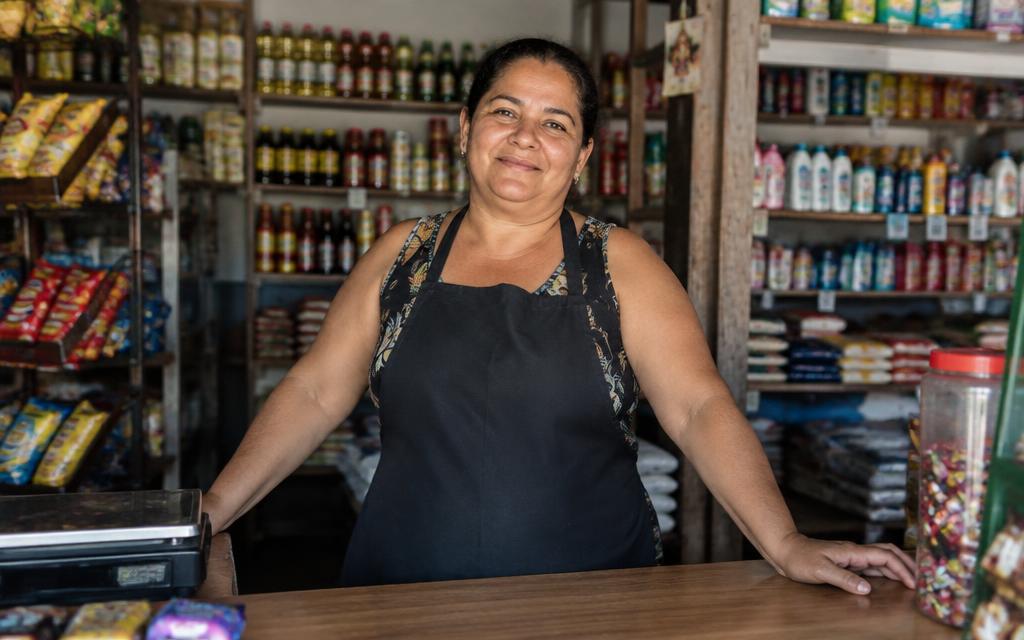 Lojista atrás do balcão da sua pequena loja de bairro